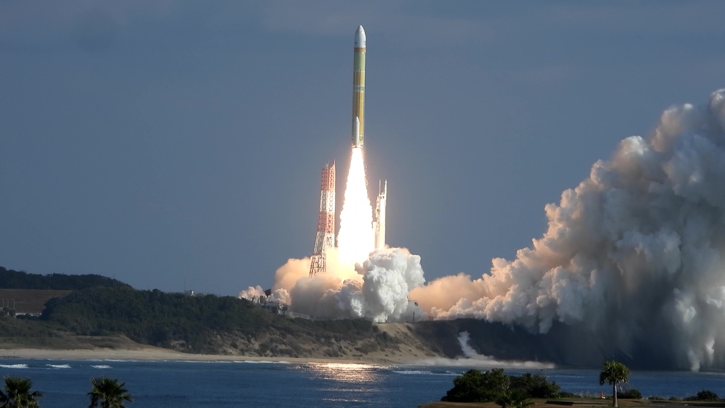 An H3 rocket lifts off from the Tanegashima Space Center by the sea